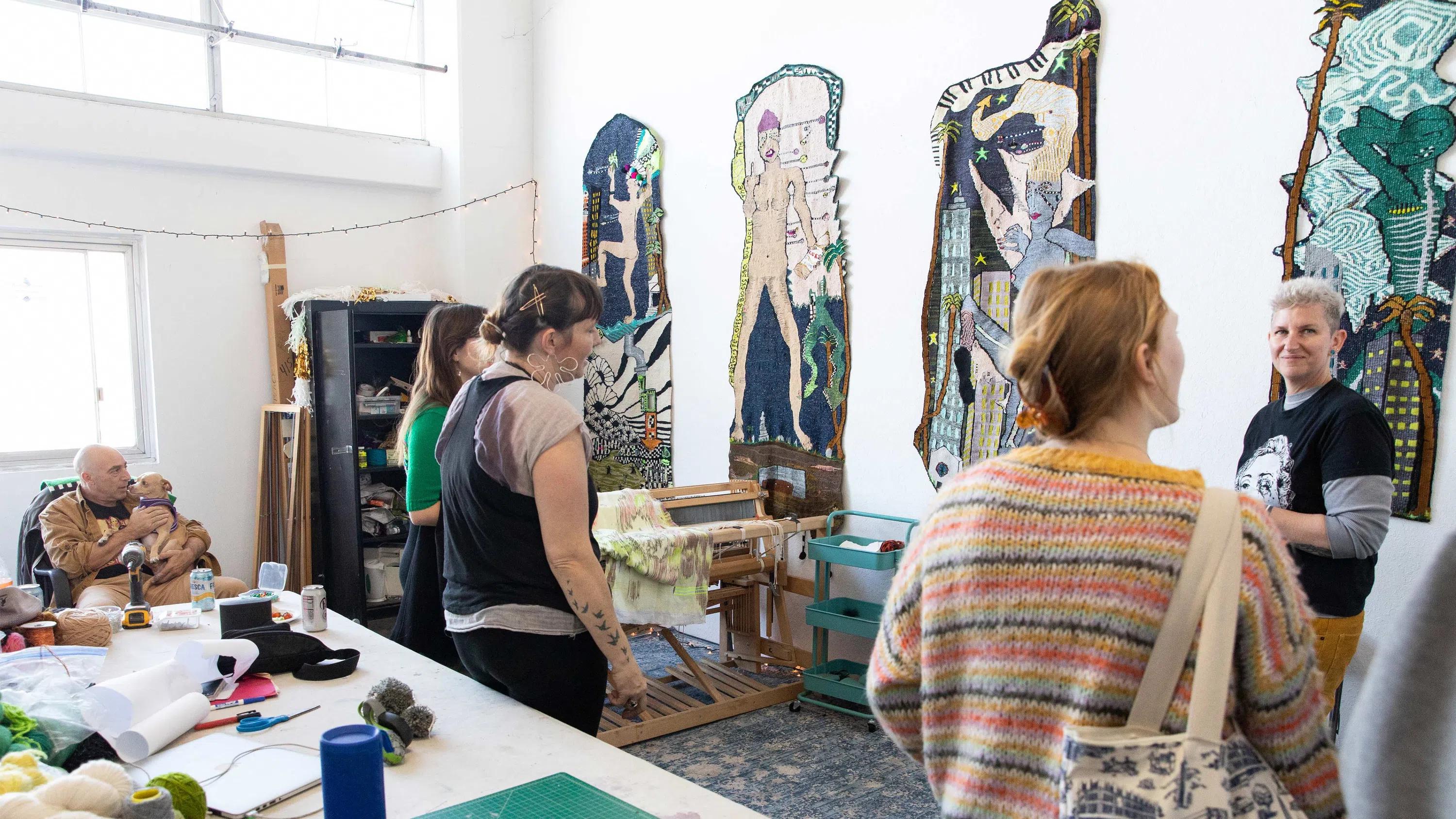 Three students look at an artwork in one of the MFA Dogpatch studio spaces.