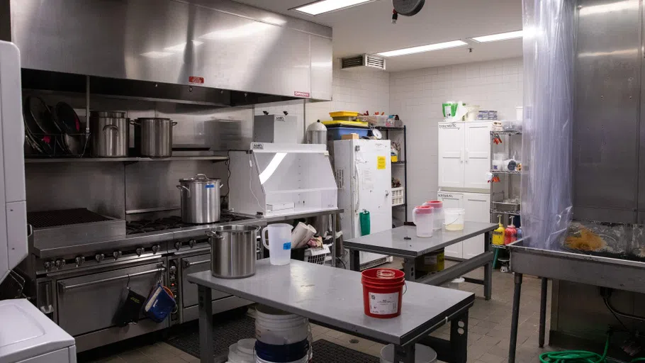 A lab with large stainless steel equipment, buckelts, and other supplies. 