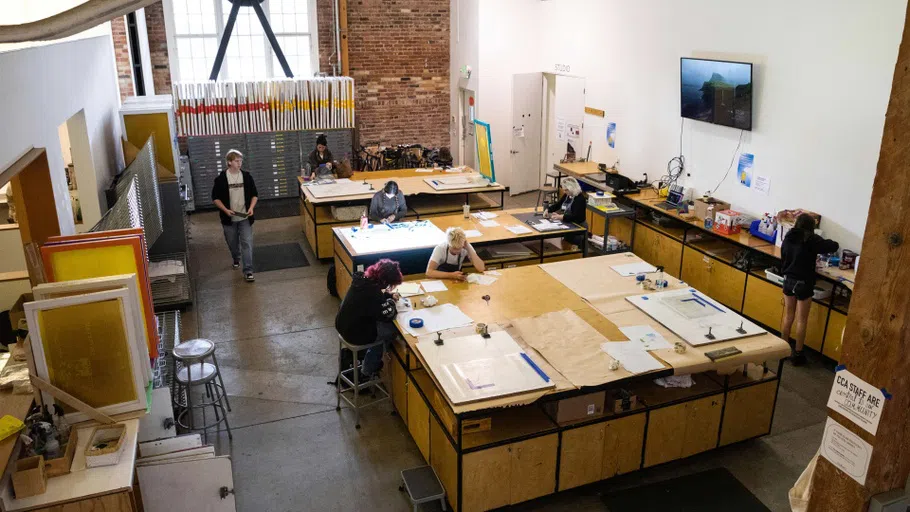  Students working around large tables. 