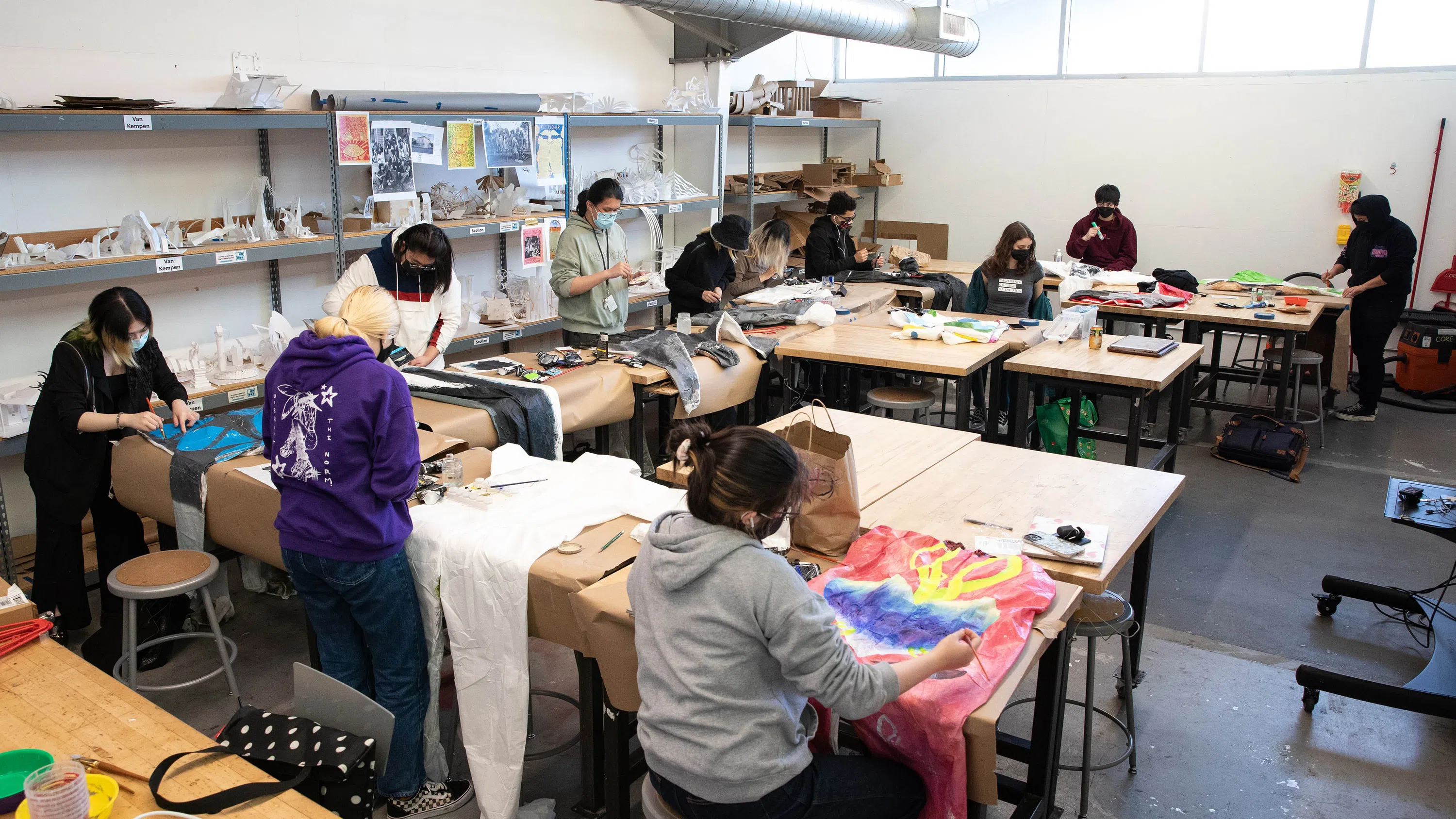 A group of students transform jumpsuits through color, collage, and painting.