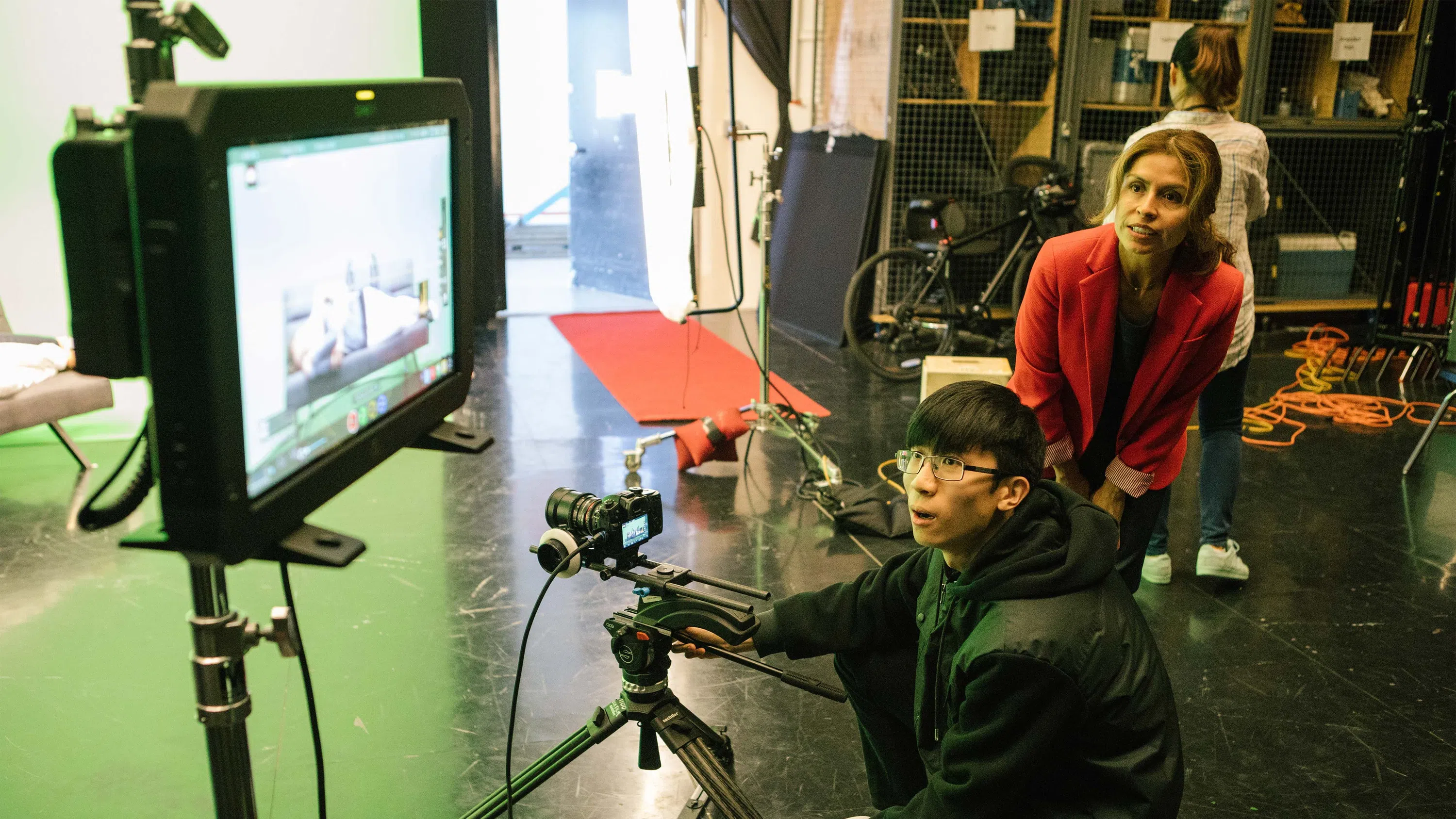 Two students see how their project looks via a monitor.