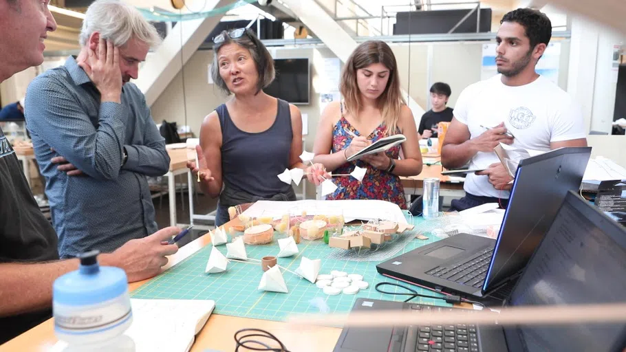 A group of students and faculty work with materials in the Architecture studio.