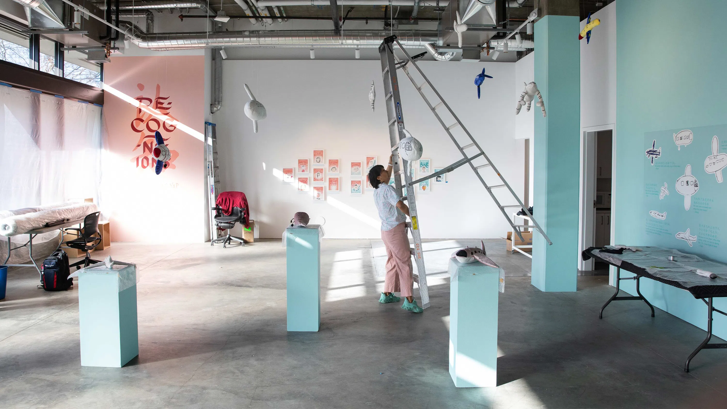 Artist Christine Wong Yap adjusts a ladder while installing her exhibition in the CCA Campus Gallery.