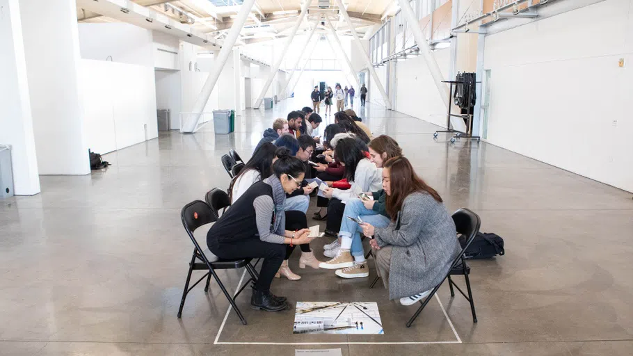 A group of students engage in lively discussion, lining the Nave in two-by-two rows of chairs.