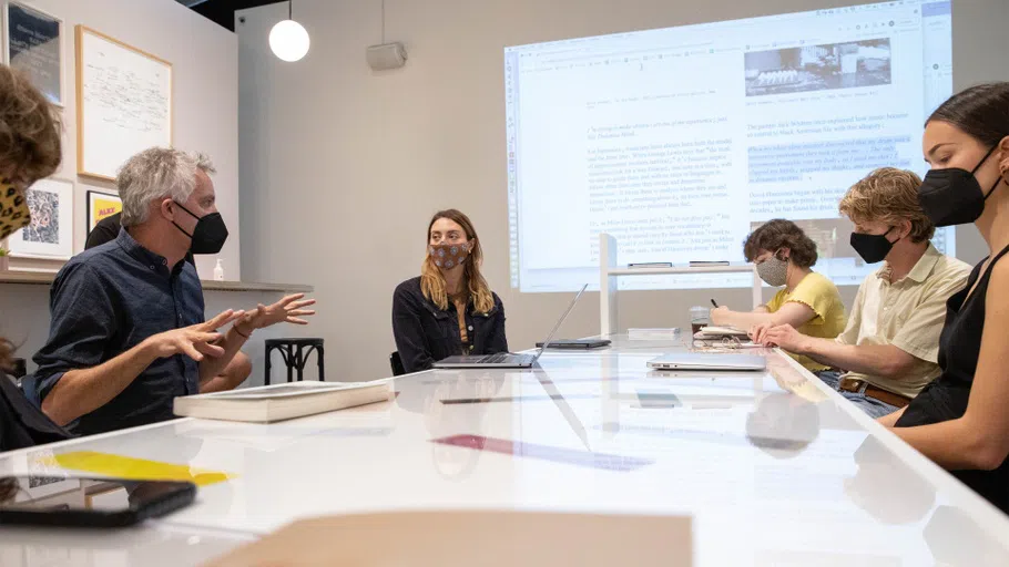 Six people sit and talk at a table.