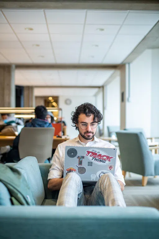 Student working on blue couch