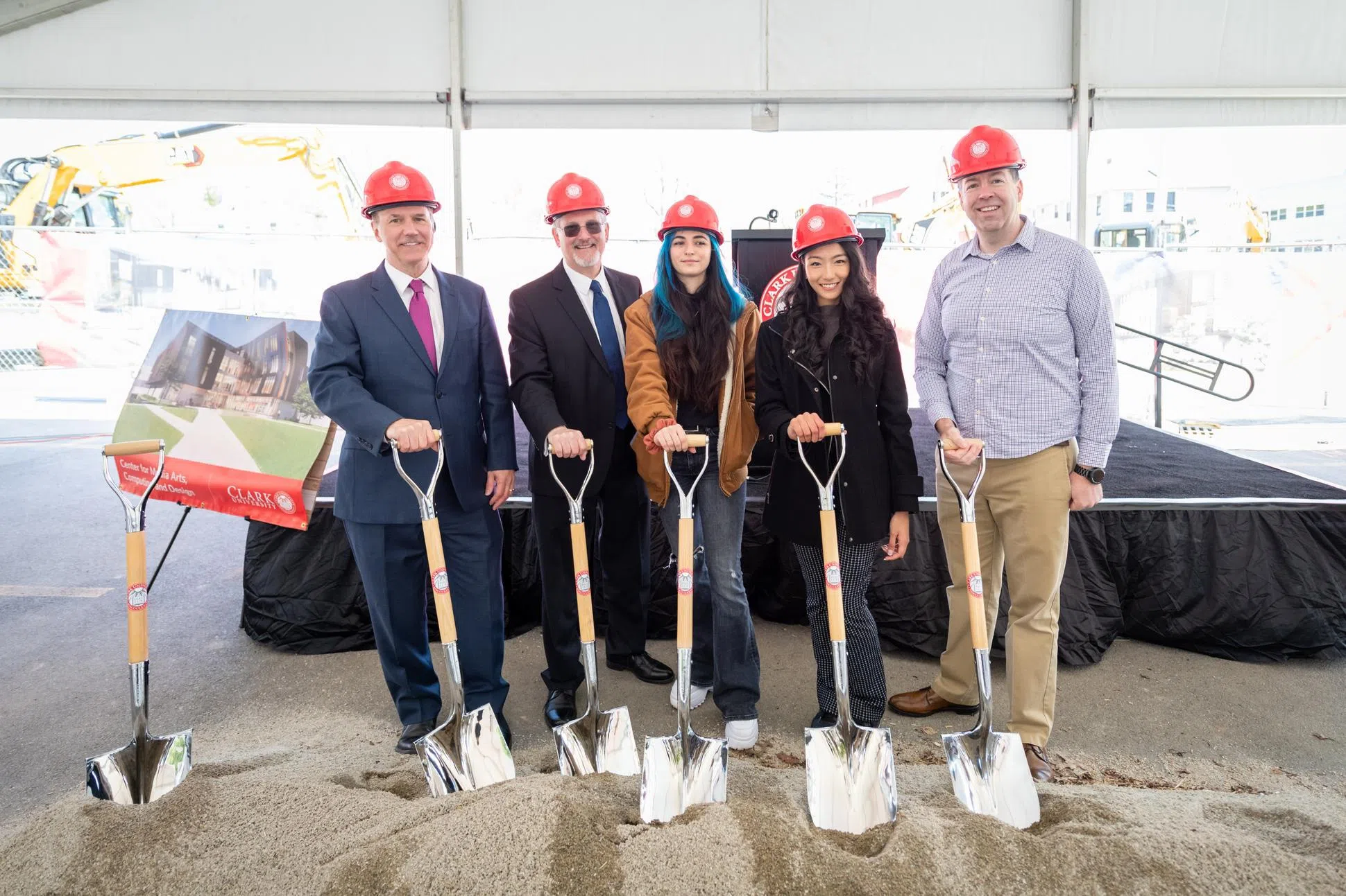 Five people in hardhats with silver shovels at groundbreaking ceremony