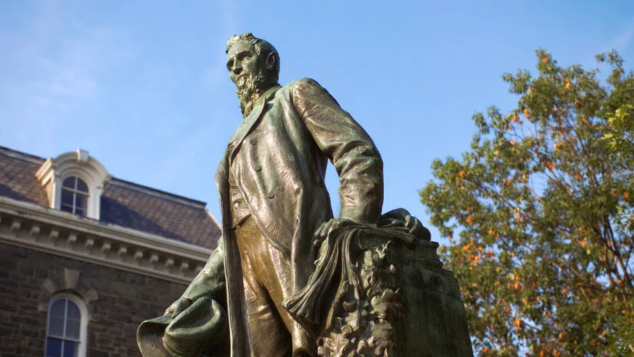 A bronze statue of Ezra Cornell, taken from below. Cornell's face looks to the left of the frame.