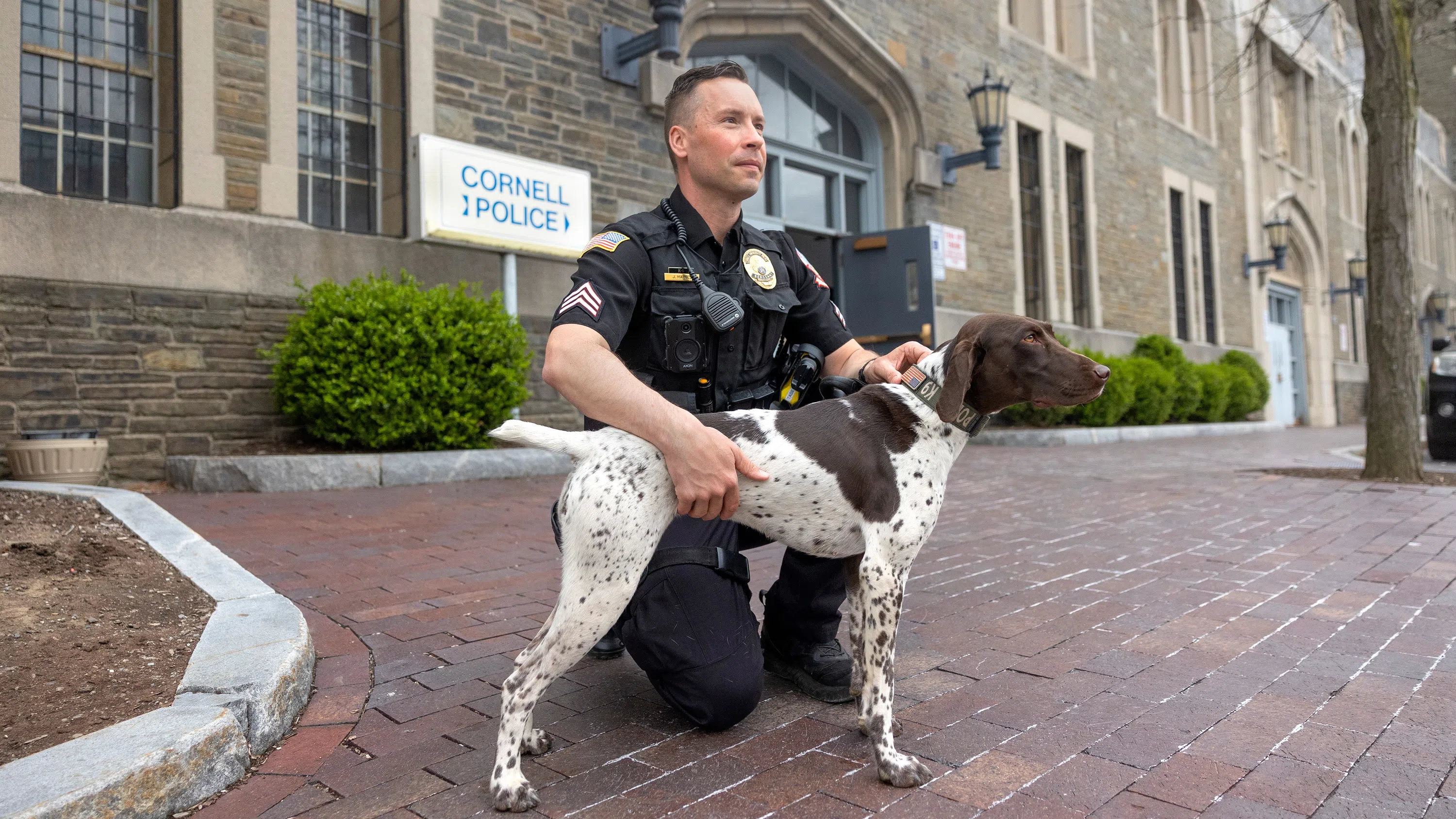 Cornell Police K-9 Luna and her handler pose outside Cornell Police headquarters at Barton Hall.