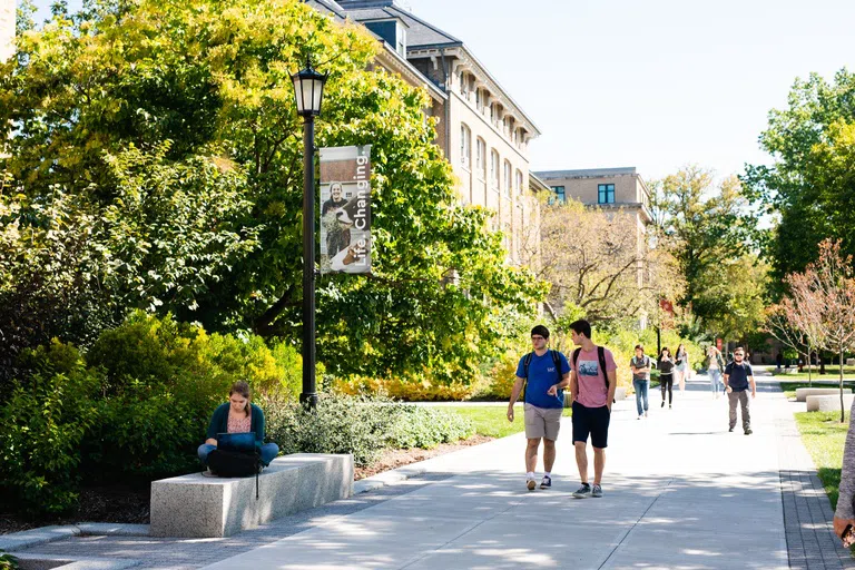 Students walk past Caldwell Hall on the Ag Quad’s many pathways on a sunny day.