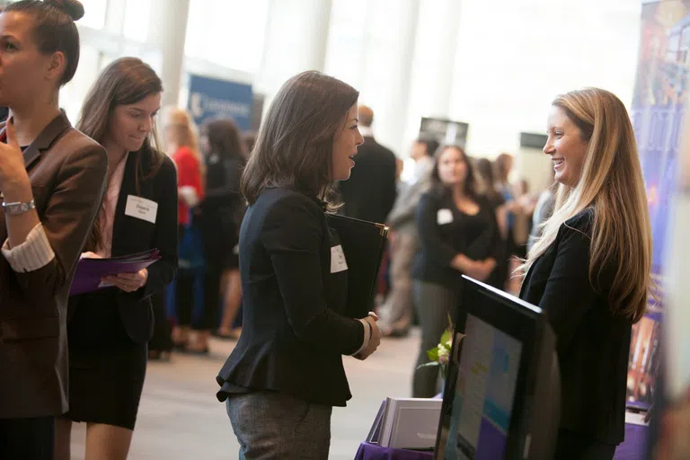 A student talks with a representative from a hospitality employer at aCornell Nolan School career fair.