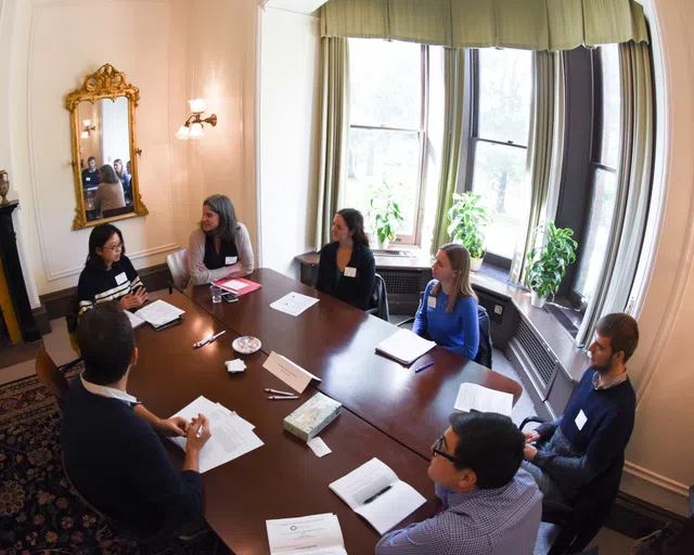 Students gather around a large wooden table inside the A. D. White House.