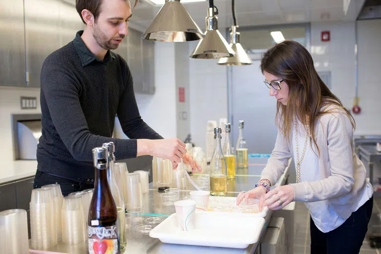 Two Food Science students test hard cider in the Sensory Evaluation Center in Stocking Hall.