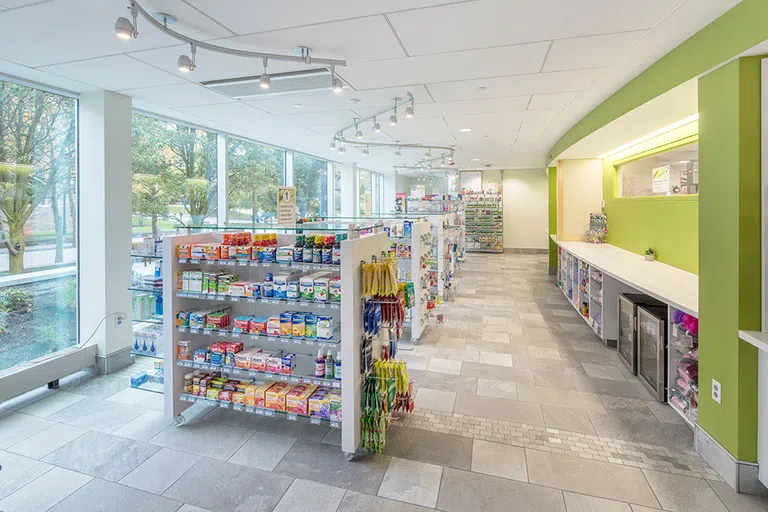 Inventory racks at Cornell Health Pharmacy, with a service counter at right.