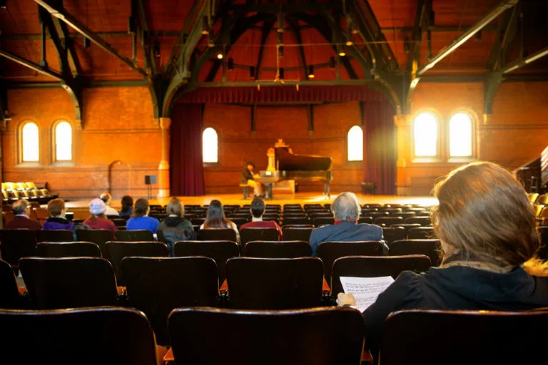 Judges follow the written music of performing students during a Cornell Concerto Competition in Barnes Hall.