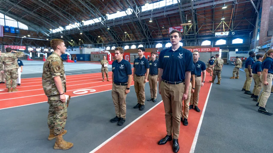 Air Force ROTC members practice drills in Barton Hall. A drill instructor, left, faces towards several college ROTC participants. They are standing on part of the indoor track inside Barton Hall. 