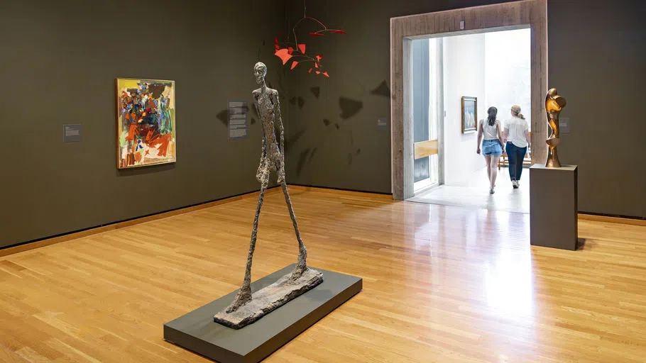 A long-legged sculpture by Swiss sculptor and painter Alberto Giacometti is at the center of the room in an exhibit at the Johnson Museum.