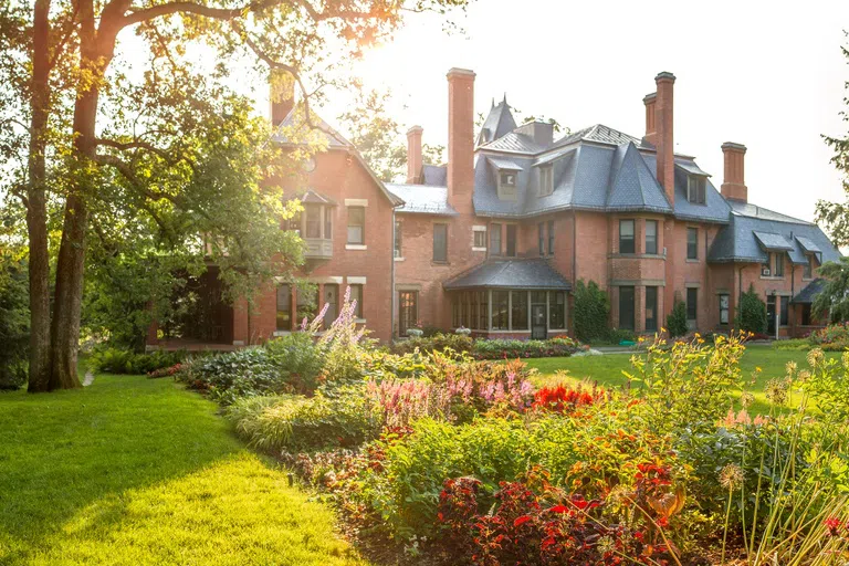 A.D. White House with flower gardens in foreground.