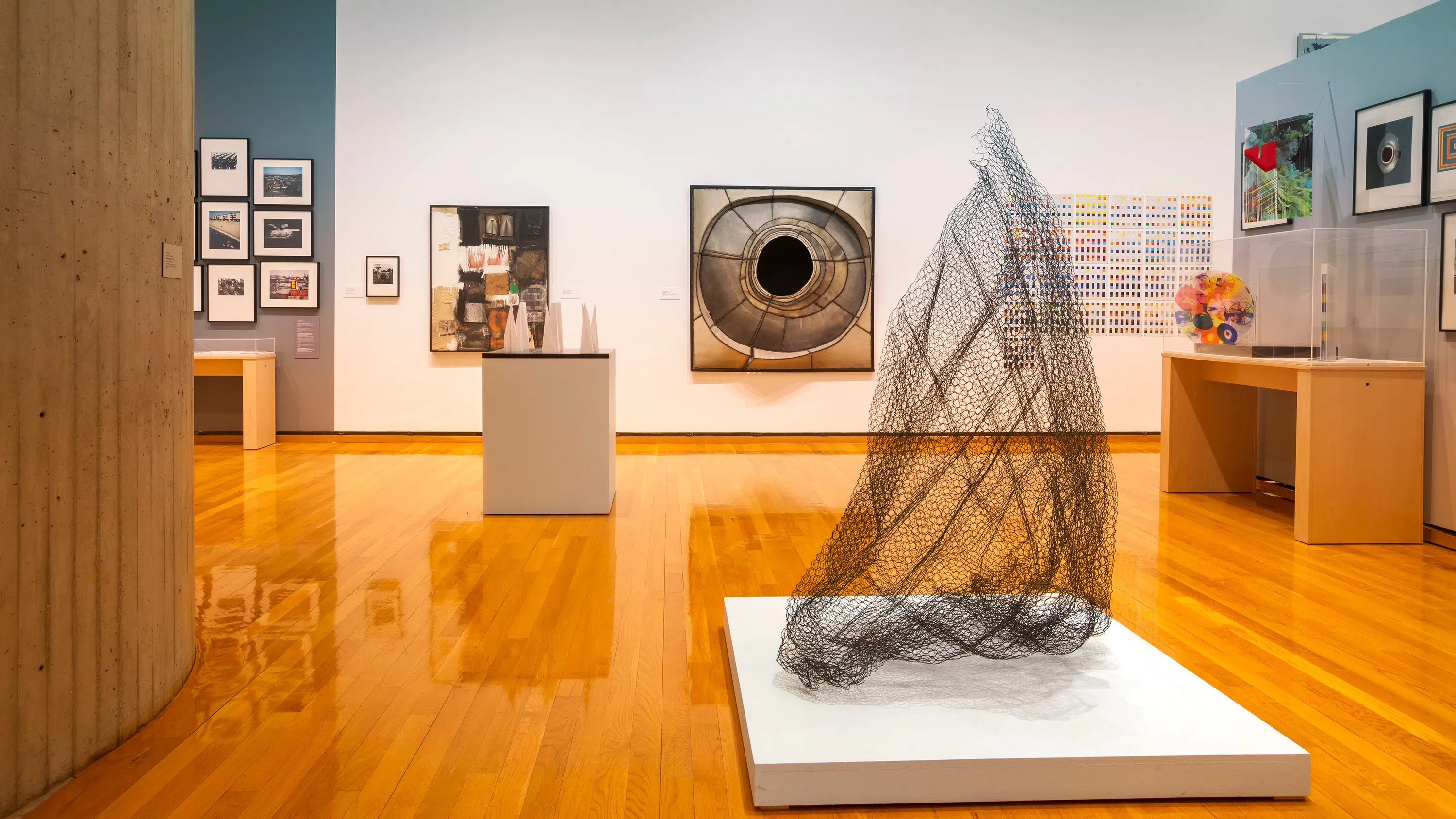 A gallery at the museum, which contains a variety of artwork including framed photographs, artifacts in a display case and mixed-media art.