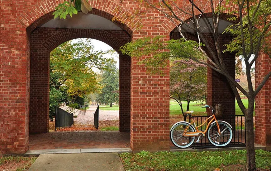 A bicycle leans agains a column of one of 4 brick archways.