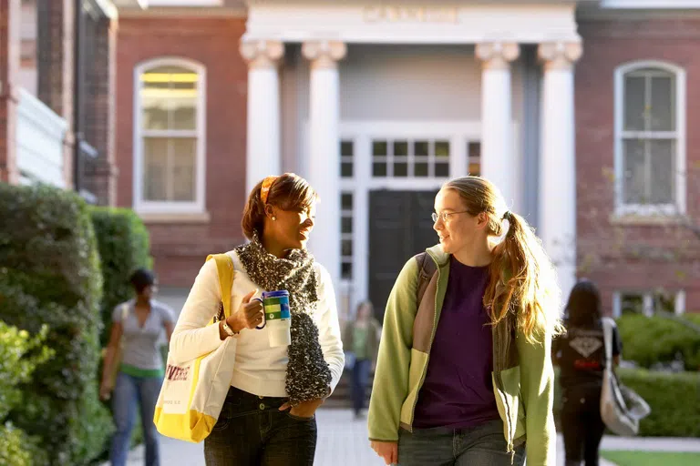 Two students talk in front of the entrance to Carnegie Hall.