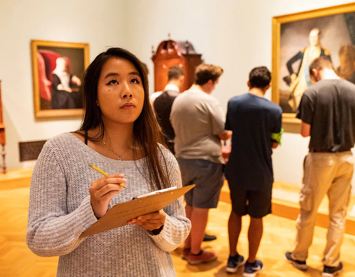 Student takes notes with examining art in the Cleveland Museum of Art
