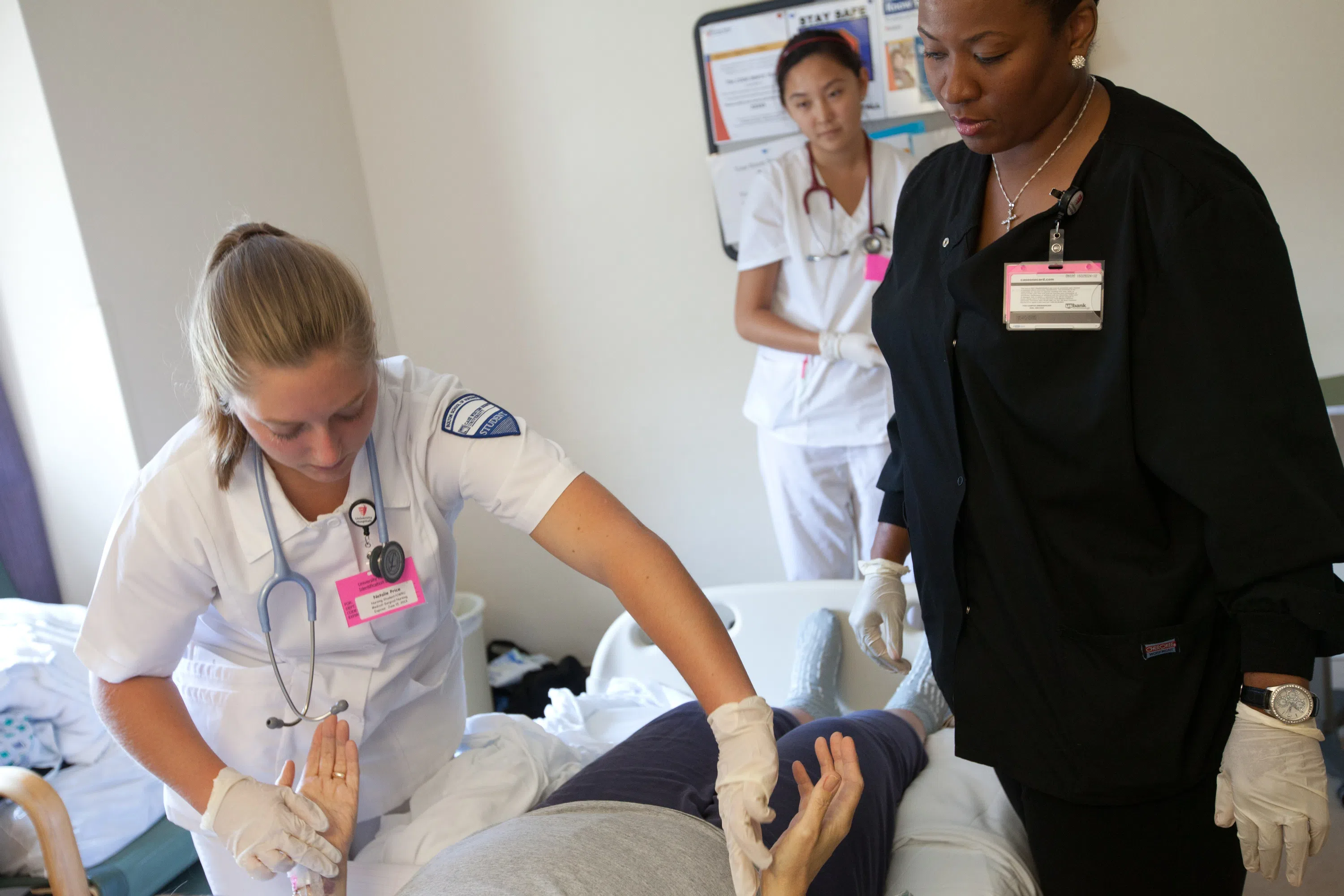 Nursing student in scrubs takes a patient's vital signs