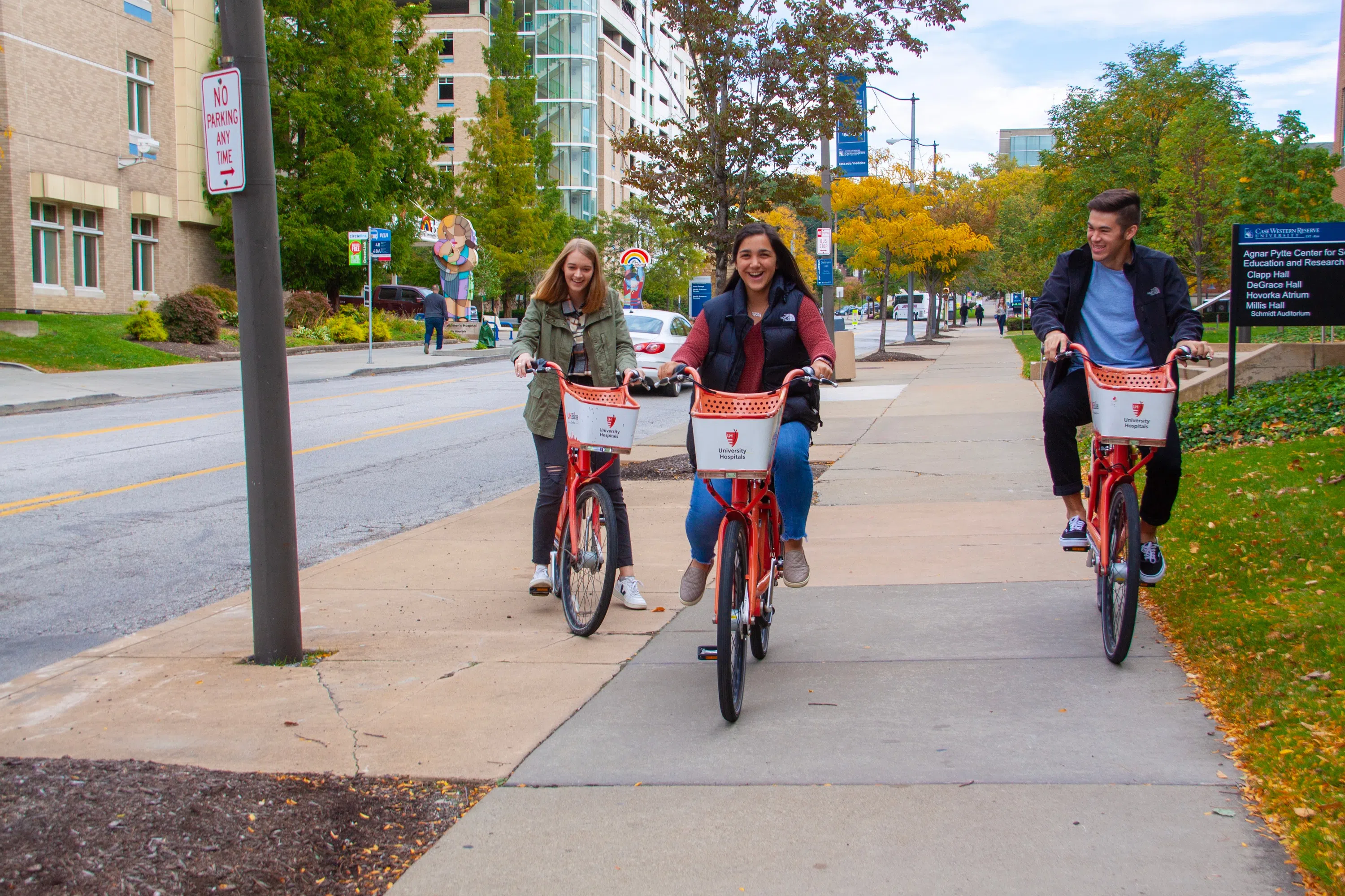 Students ride bikes in front of University Hospitals on CWRU's campus