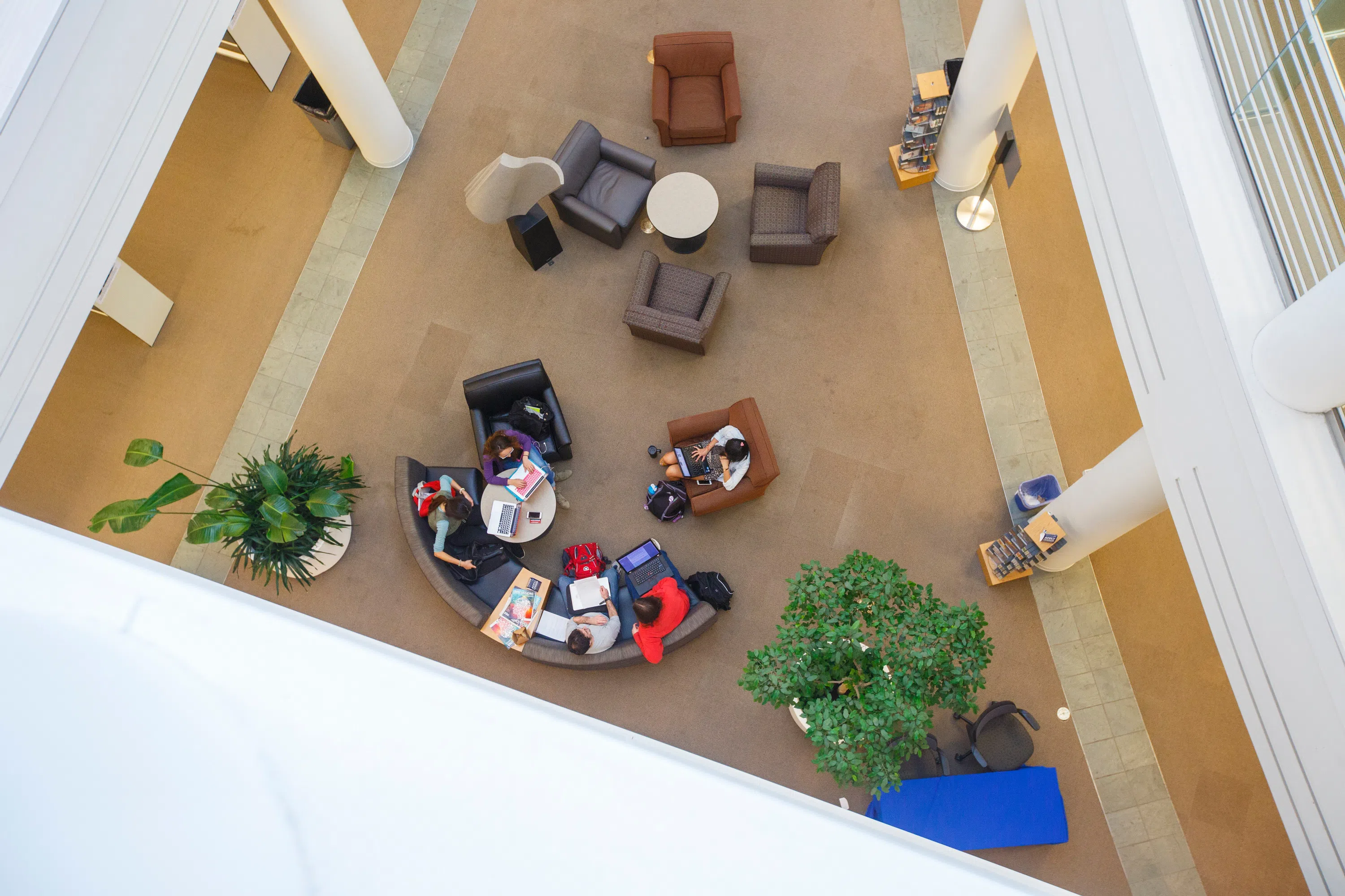 Looking down at students sitting on couches working on computers in the library