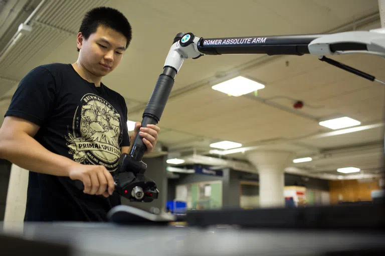 Student works with robotic arm equipment