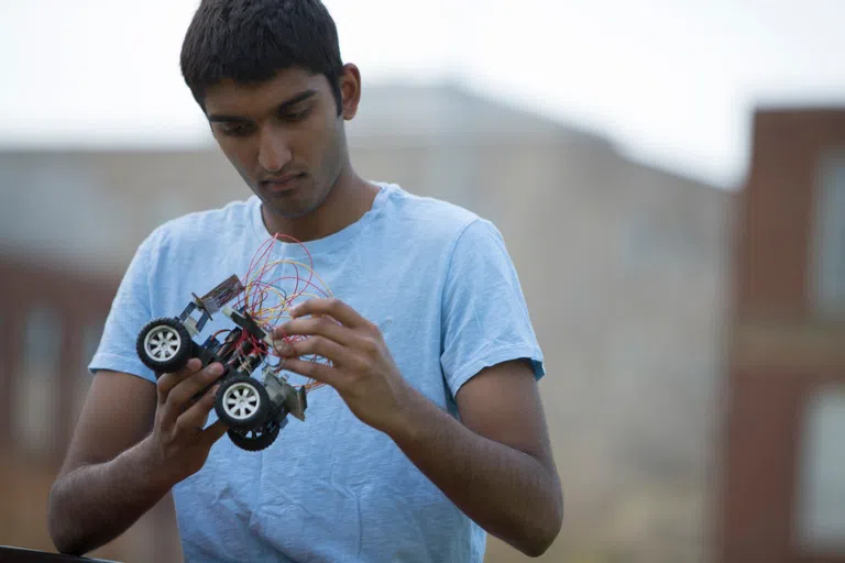 Close up of student holding a toy solar panel car