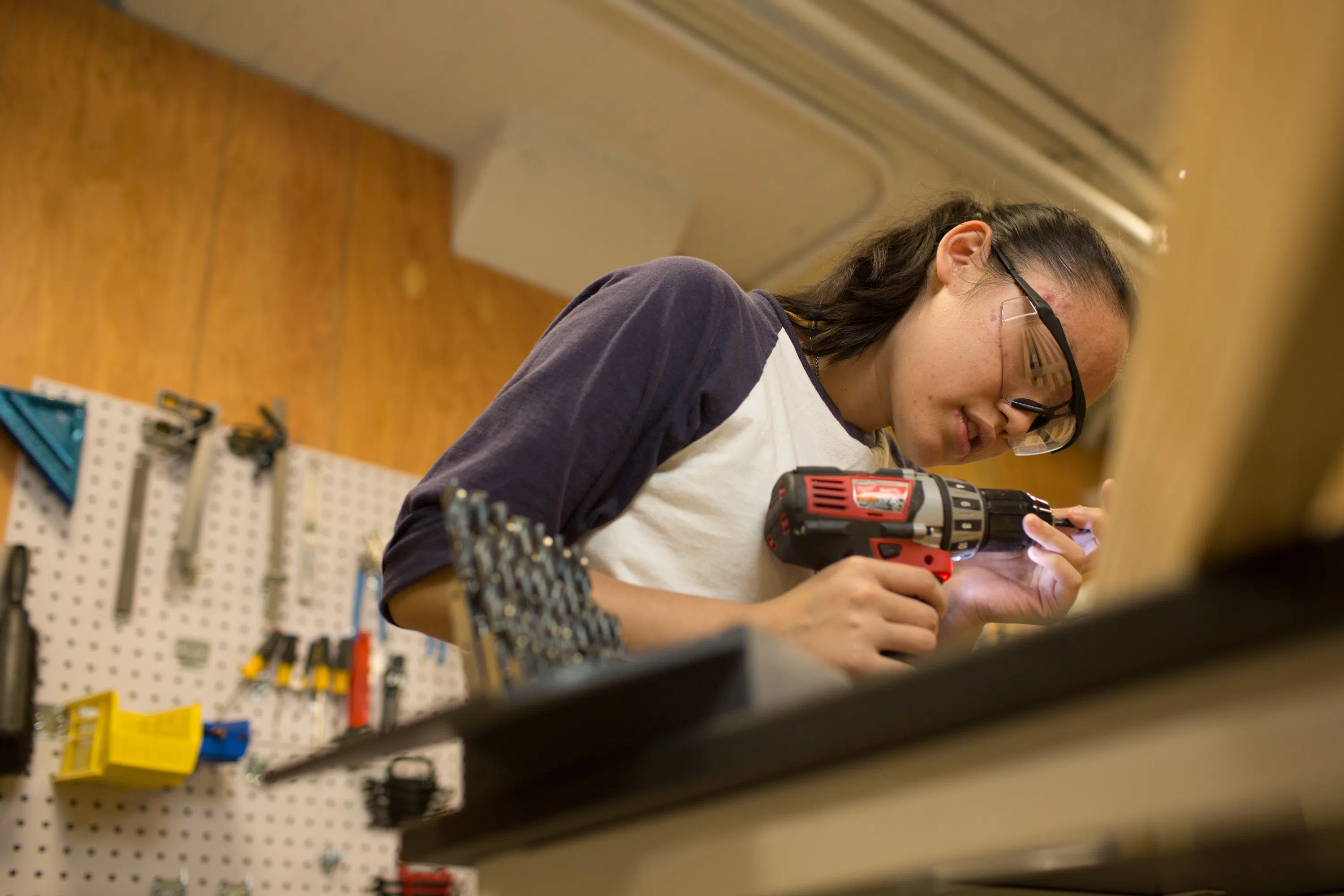 Student holding a drill and working