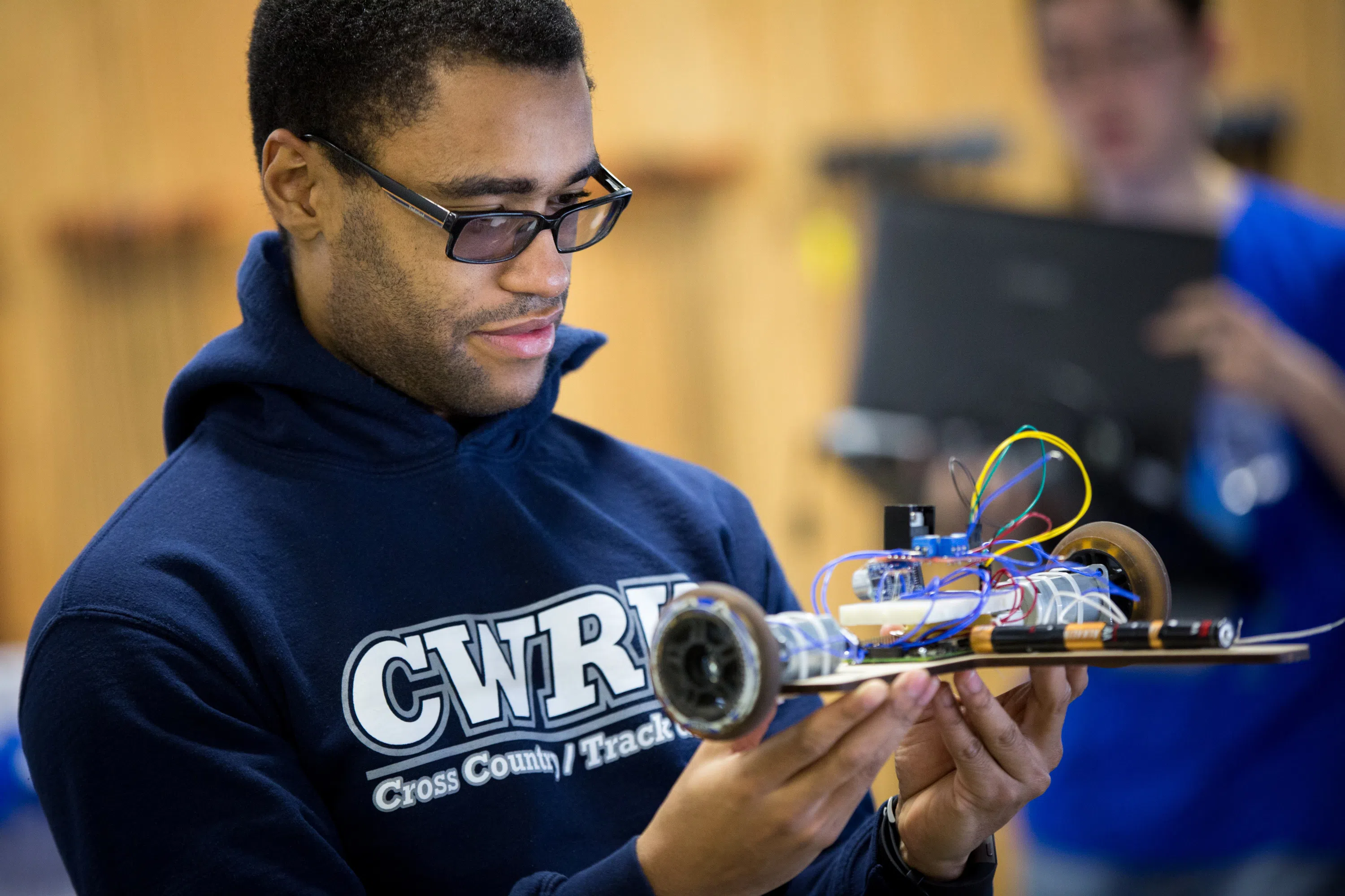 Closeup of student holding an electronic device made at think[box]