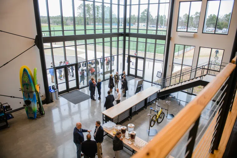 A crowd gathers in the atrium of the Andy Quattlebaum Outdoor Education Center.