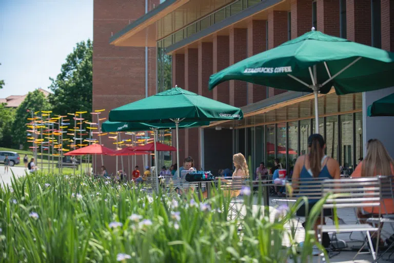 Students sit outside the Starbucks in West Campus.