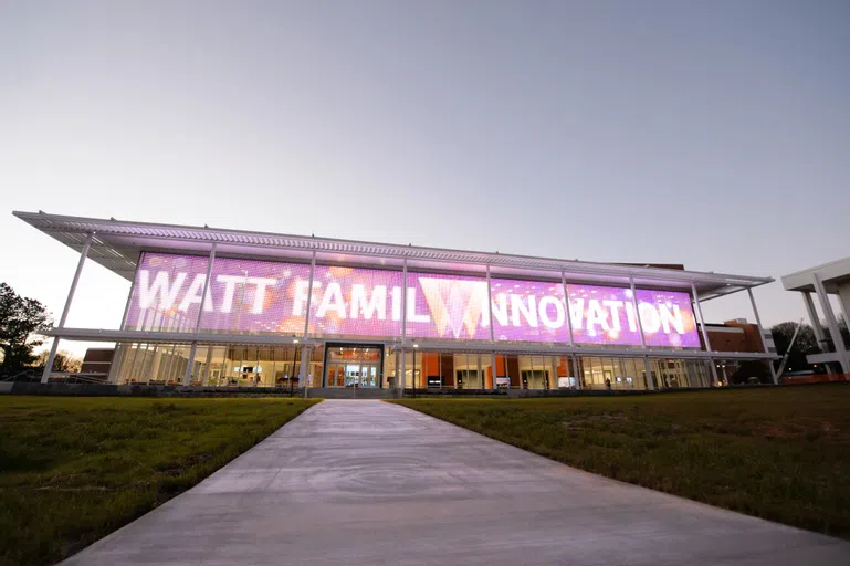 The media display on the front of the Watt Family Innovation Center lit up at dusk.