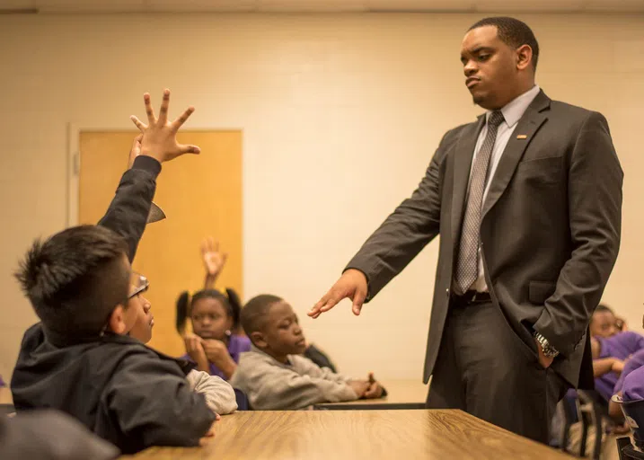 A Call Me MISTER teacher laughs with a group of students.