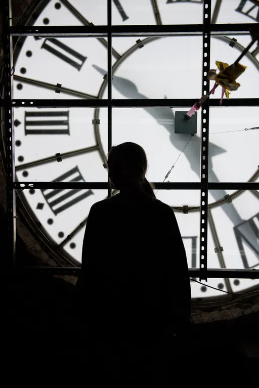 A student stands at the top of the clock tower.