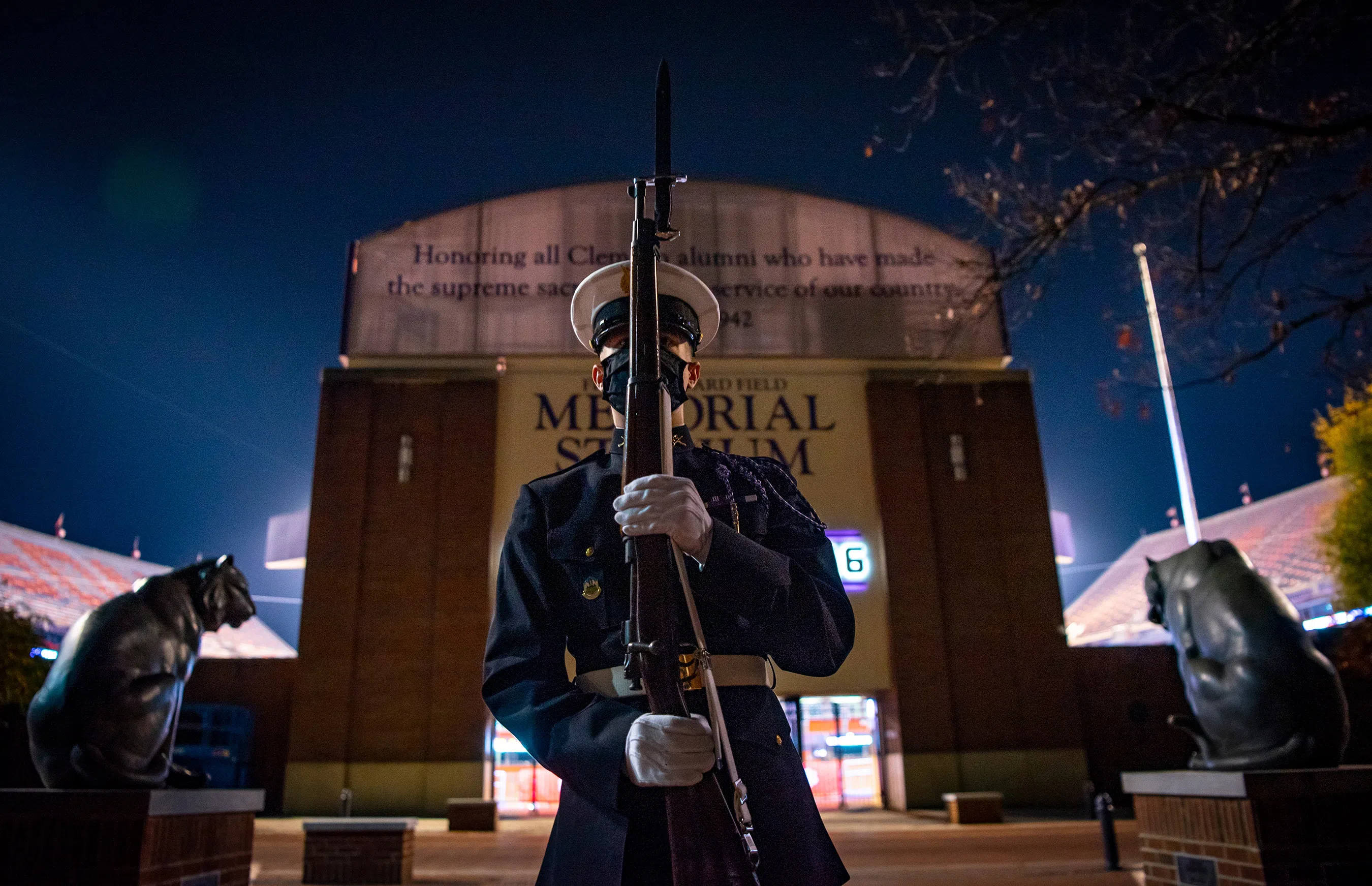 A guard stands outside Memorial Stadium and the Scroll of Honor.