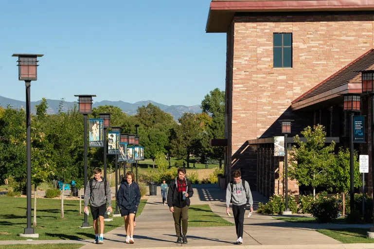 Students walking on campus with mountains in the background