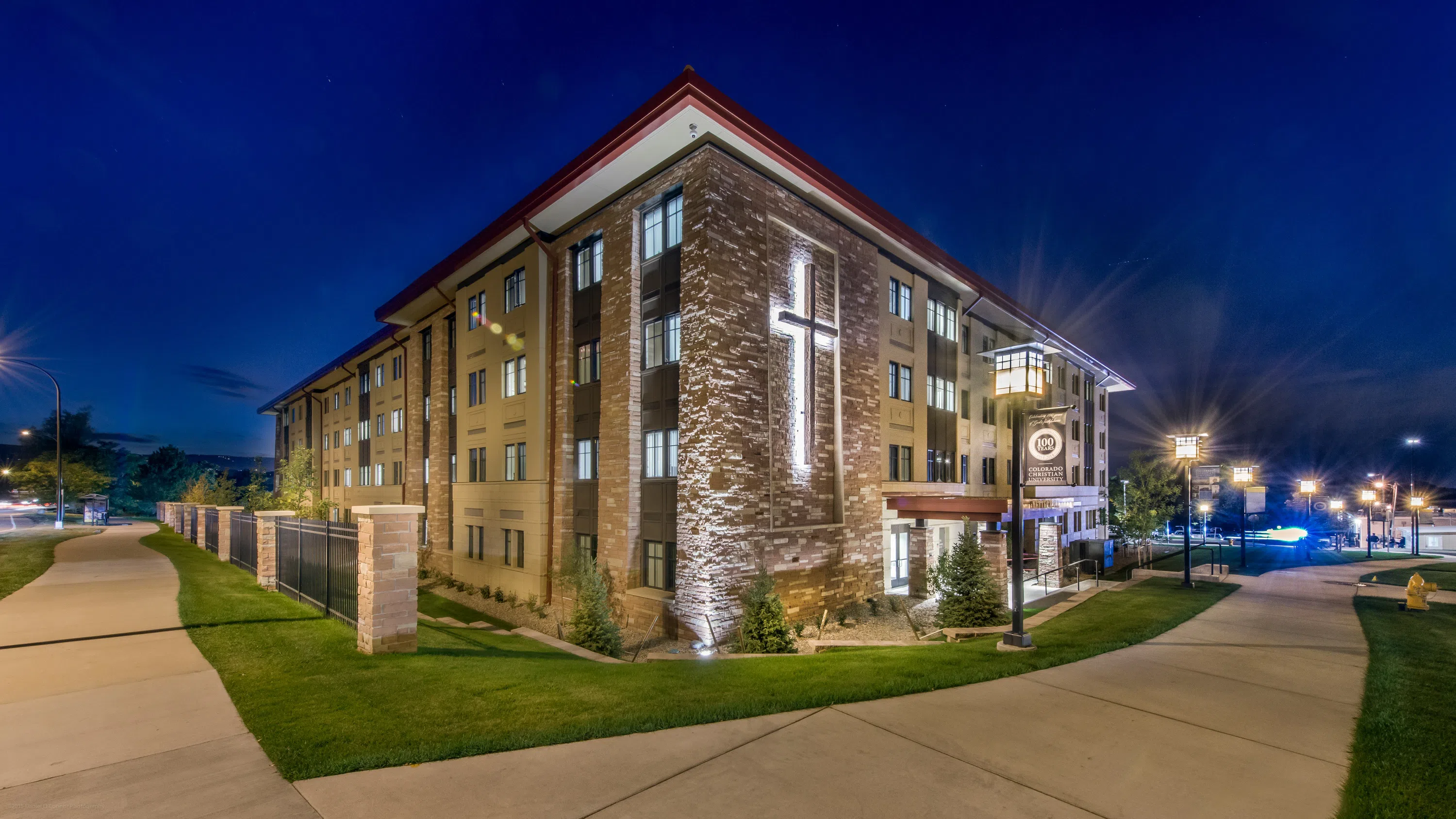 Yetter apartments lit up at night with an illuminated cross on the side