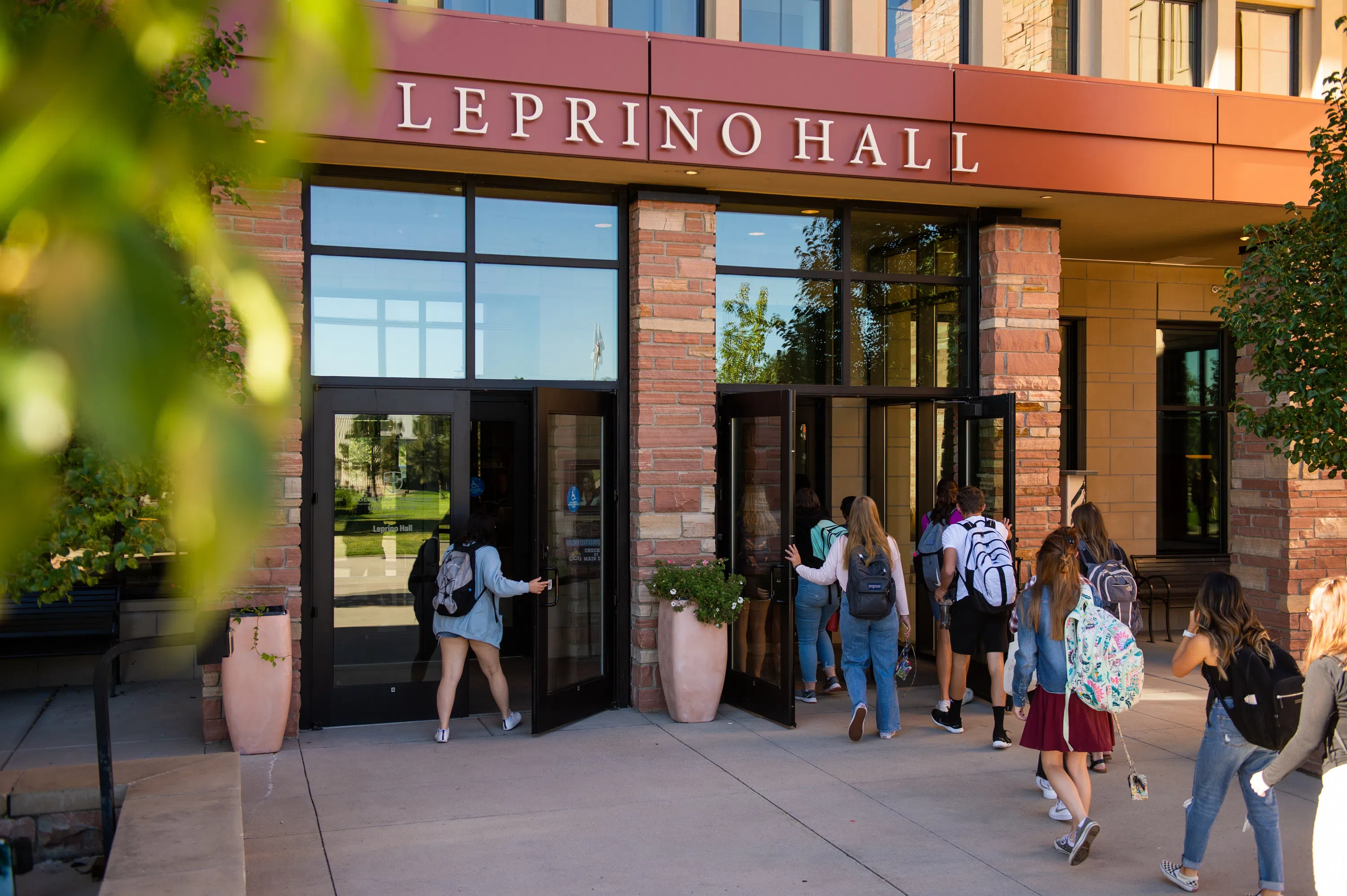 Students walking in the two sets of double doors at Leprino Hall