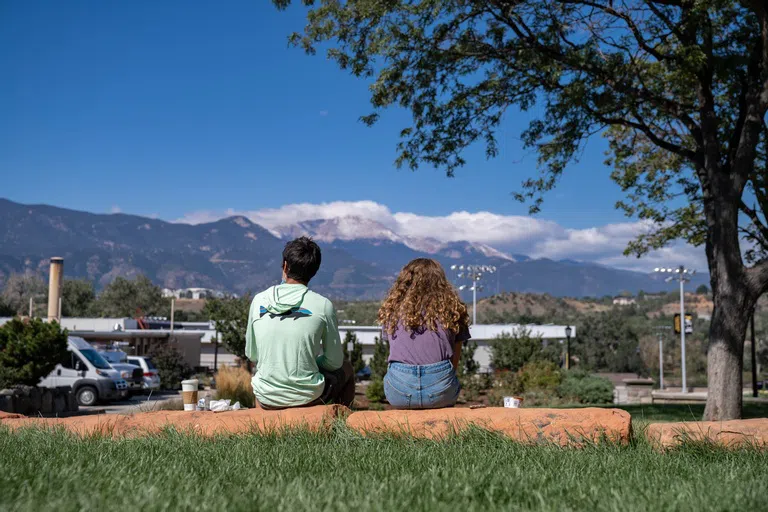 two students facing west toward Pikes Peak