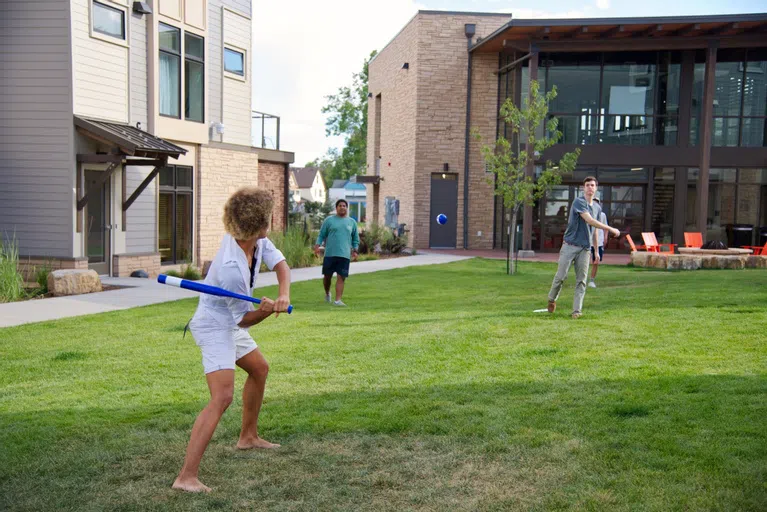 Students playing baseball outside of East Campus Housing Complex