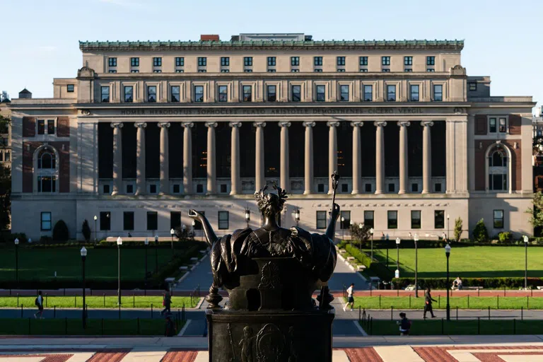 Wide angle view of Butler Library with bronze statue of alma mater in the foreground