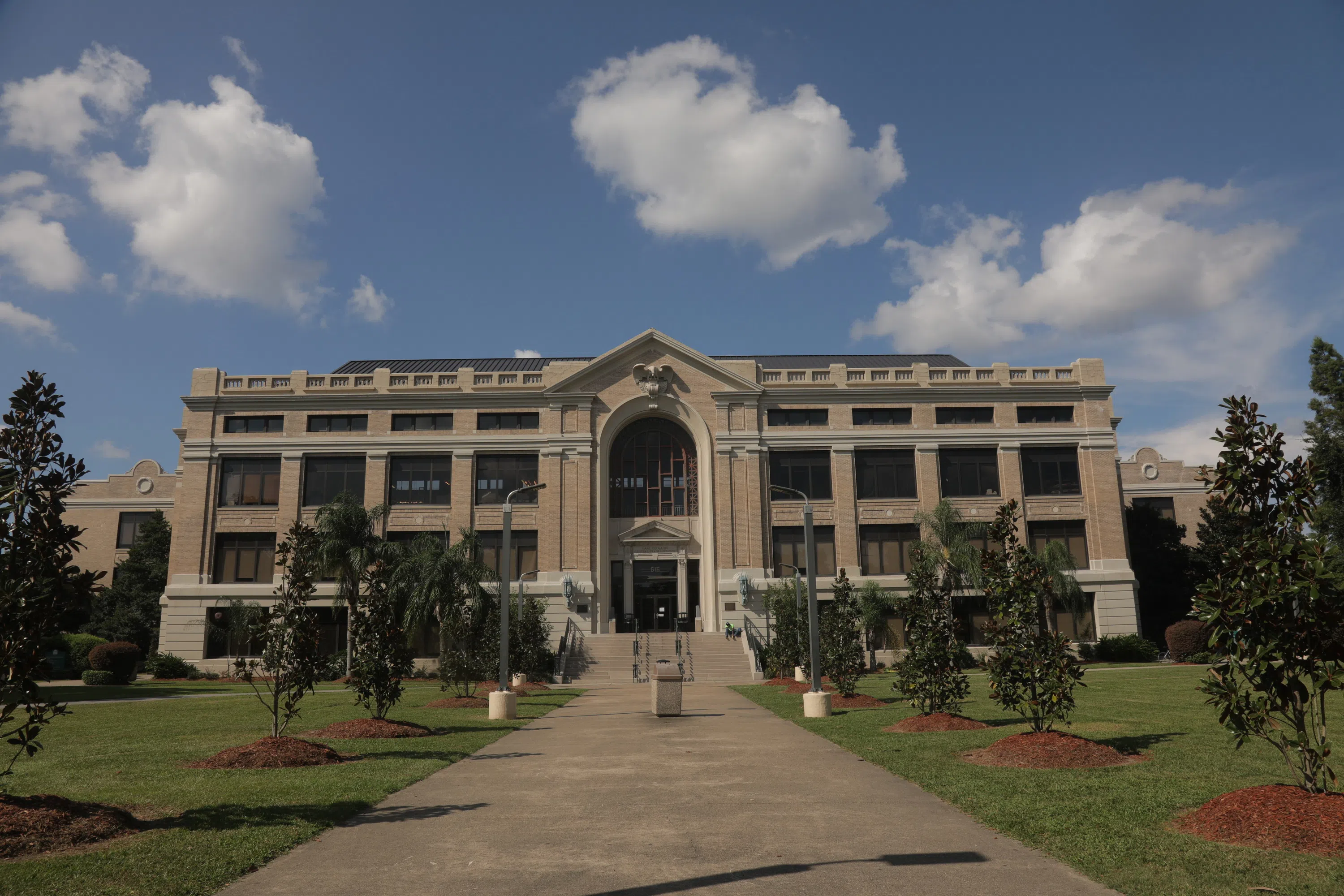 beige building with palm trees in front