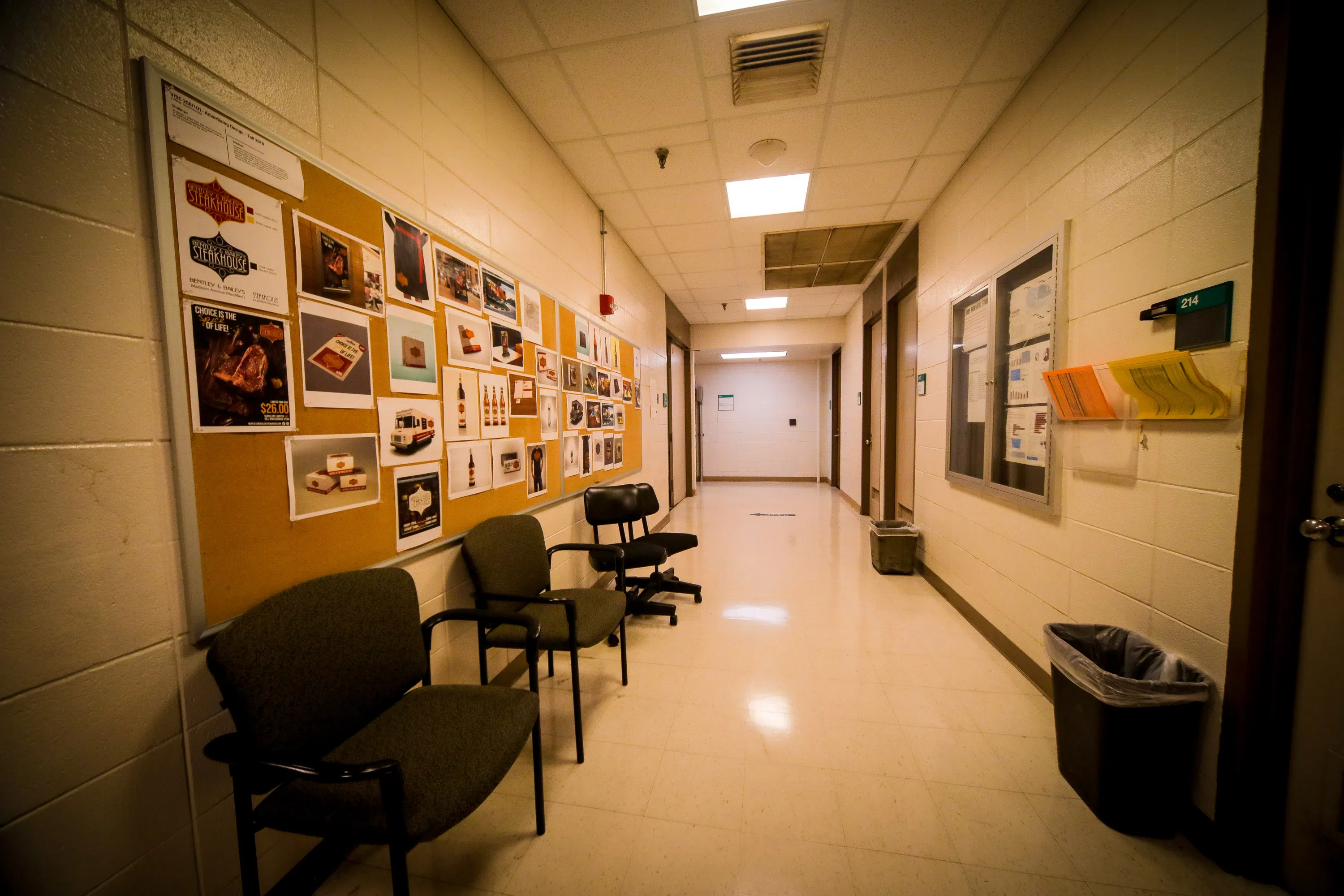 hallway with art work pinned to bulletin boards on the left side