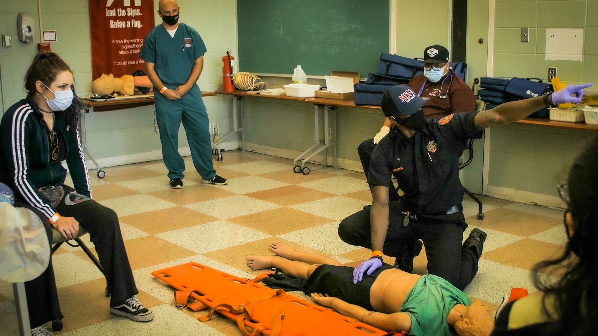 students in EMT classroom practicing saving a dummy