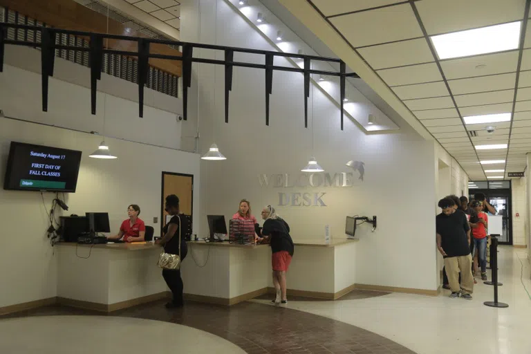 open space with a corner desk and people speaking with each other