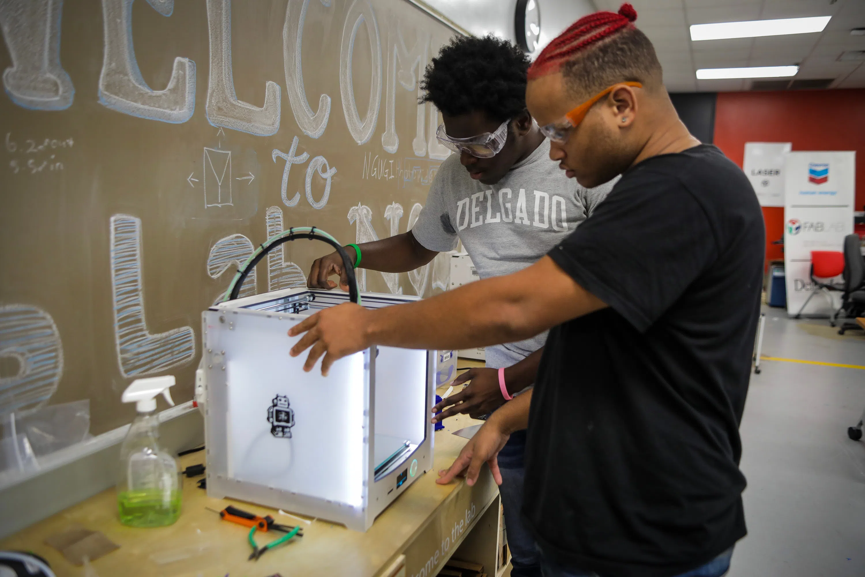 2 people working at a 3D printer